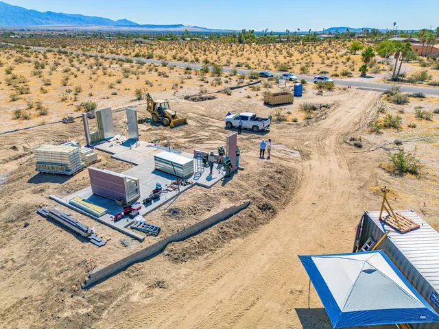 Aerial view of the Borrego Springs site with labeled 4C panels staged on the slab and the first walls standing
