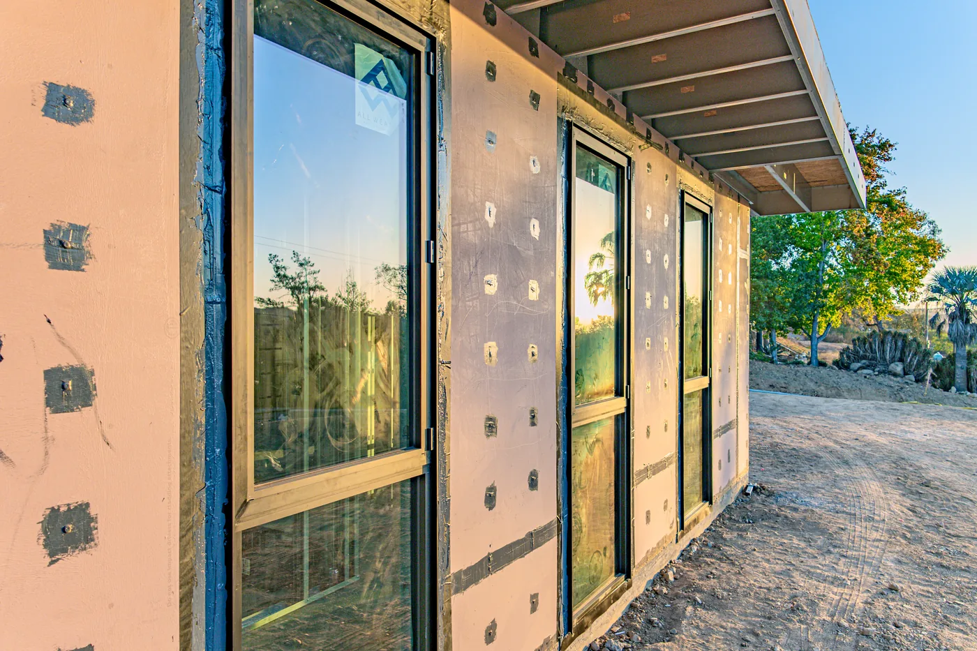 All Weather swing door and windows installed along the Escondido Residence exterior at sunset