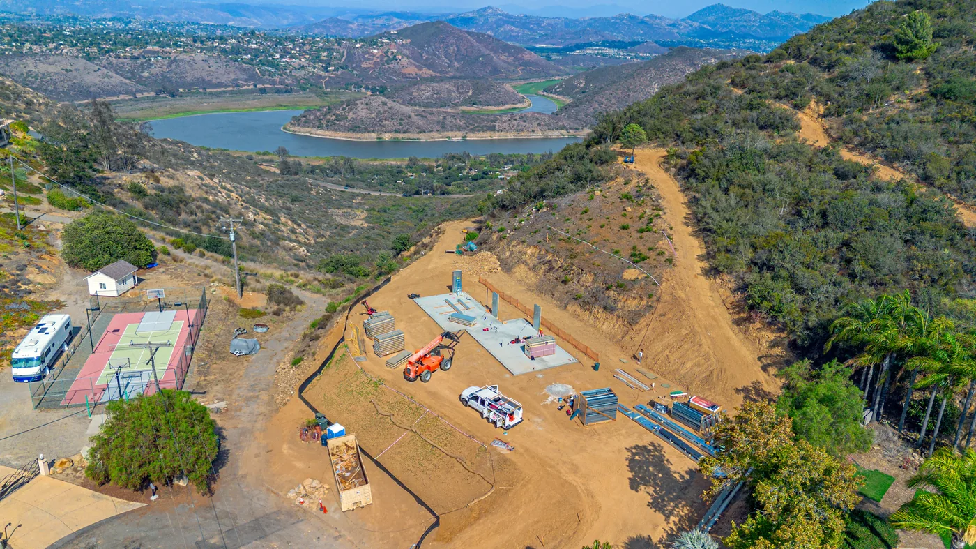 Aerial view of the Escondido site early in construction, foundation slab poured and the first wall panels going up on the hillside pad