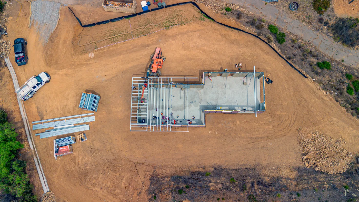 Overhead view of the Escondido foundation slab and steel framing taking shape on the hillside pad