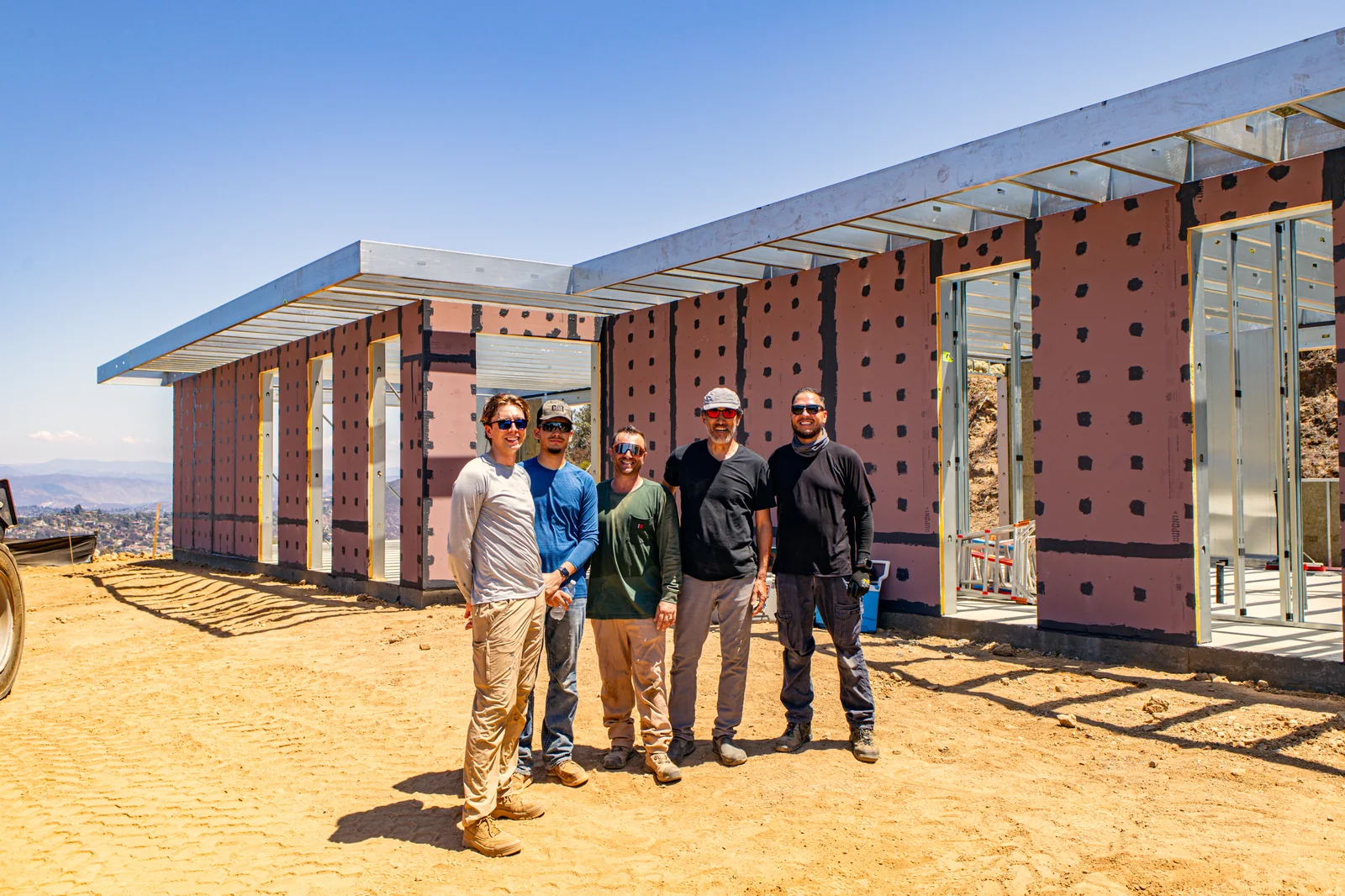 The 4C team and the homeowners together on site at the Escondido Residence, standing in front of the completed SAFE wall panels