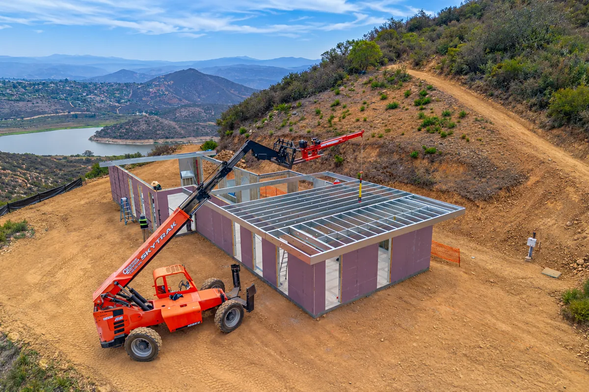 Telehandler setting steel roof framing on 4C SAFE wall panels at a hillside home in Escondido, California